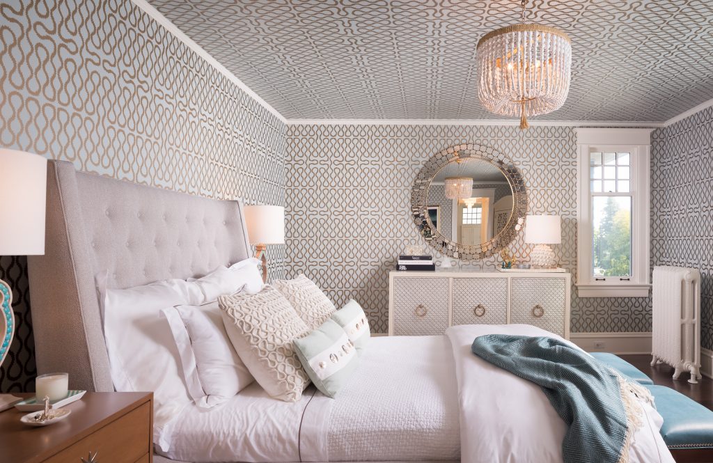 Fearless Style Fit for a Family, Master Bedroom featuring geometric and classic wallpaper, blue metallic wallcovering, white beaded chandelier, jewel box style master bedroom, circle accented mirror, coastal style family home