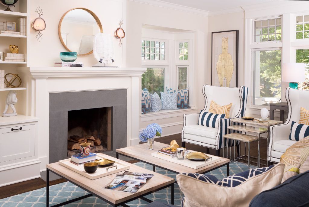 Fearless Style Fit for a Family, Living Room featuring navy blue stripped armchairs, geometric blue rug, circle mirror, gold accented artwork, horse inspired artwork, coastal style family home