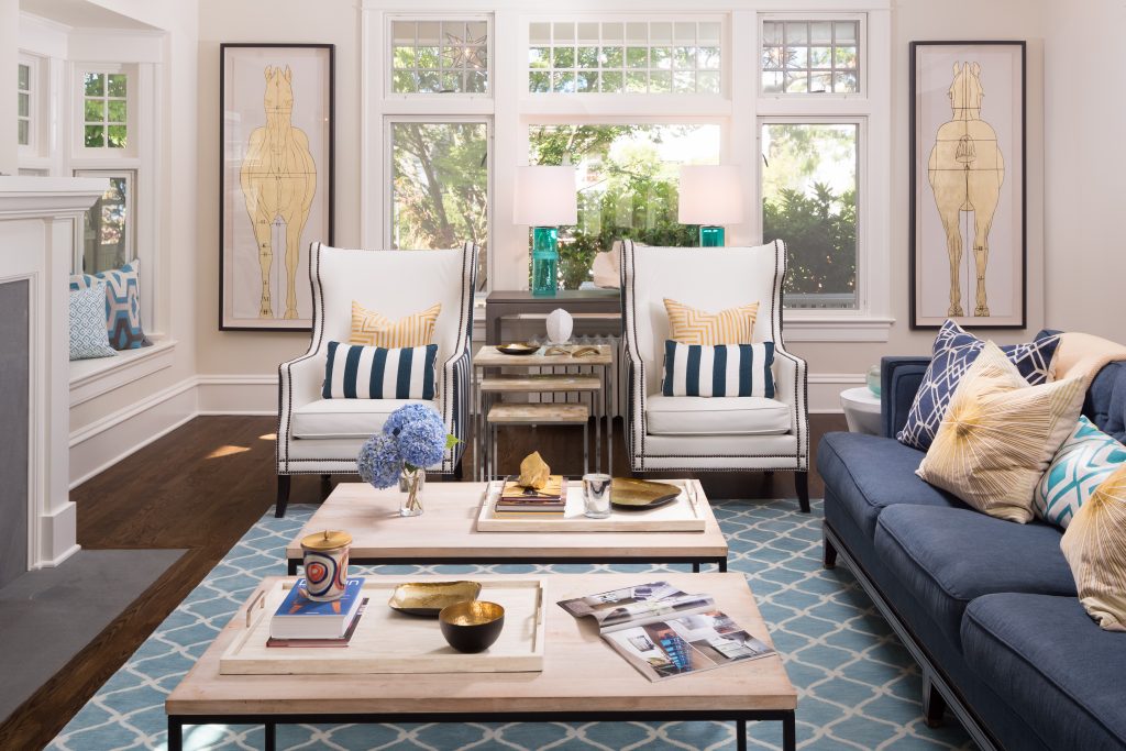 Fearless Style Fit for a Family, Living Room featuring navy blue stripped armchairs, geometric blue rug, circle mirror, gold accented artwork, horse inspired artwork, coastal style family home, coffee table styling