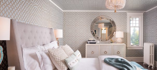 Fearless Style Fit for a Family, Master Bedroom featuring geometric and classic wallpaper, blue metallic wallcovering, white beaded chandelier, jewel box style master bedroom, circle accented mirror, coastal style family home